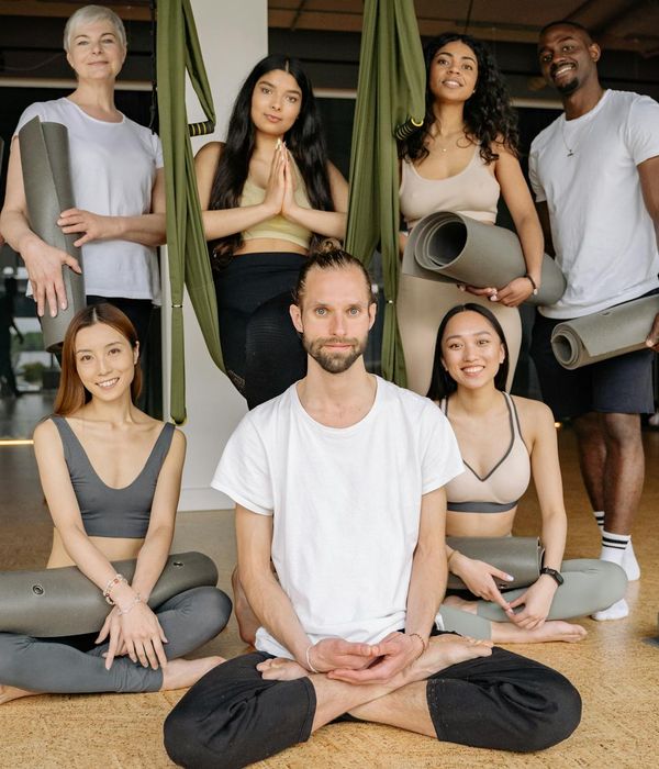 Group of diverse people starting a yoga class in a bright studio.